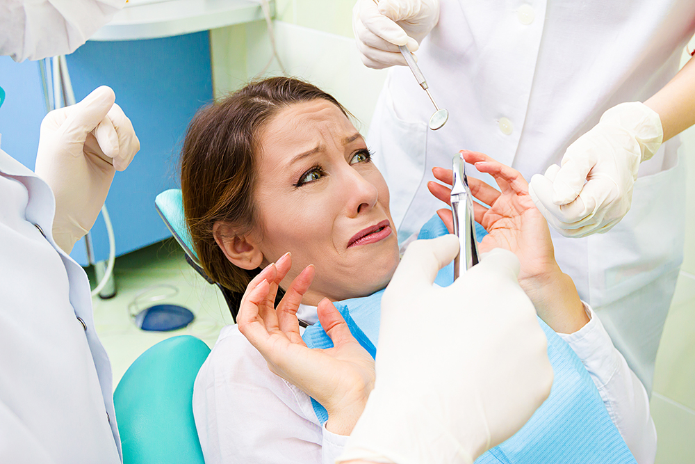 Female patient in dentist office scared, afraid of doctor, proce Female patient in dentist office scared, afraid of doctor, proce